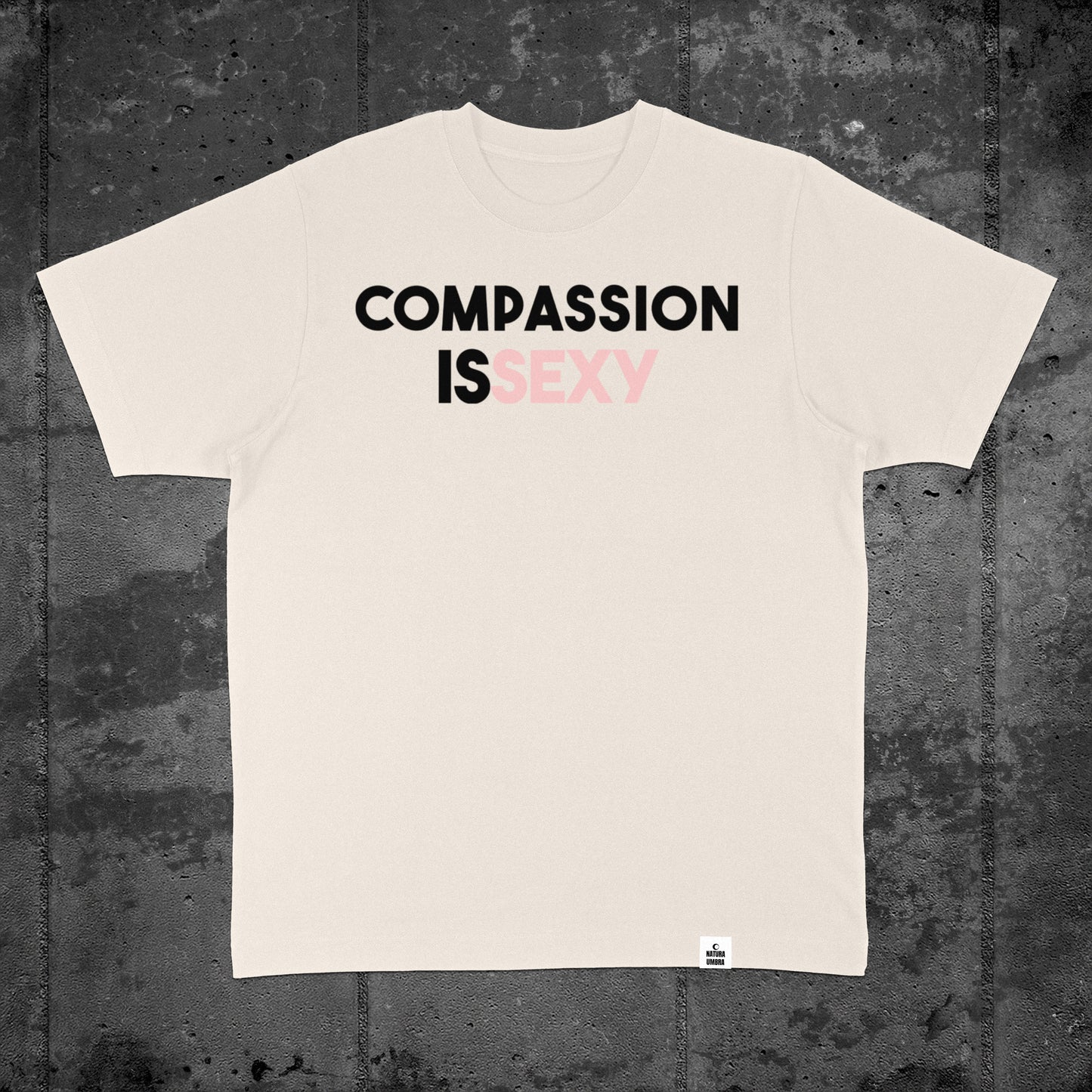 Nachhaltiges Oversized Unisex T-Shirt von Natura Umbra in Natural Raw mit Frontprint „Compassion is sexy“ – Flatlay des Stanley/Stella Freestyler.