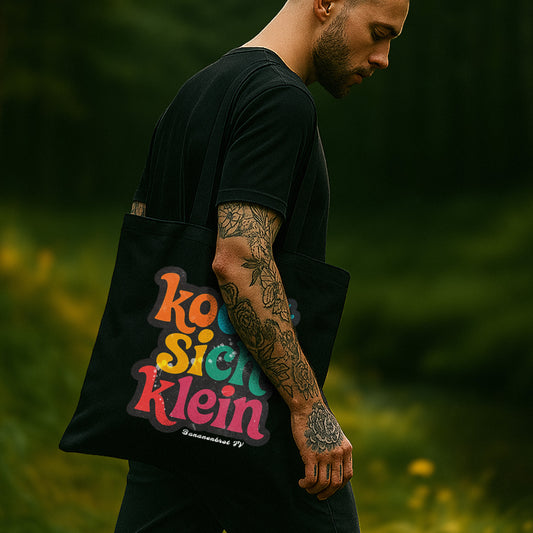 Nachhaltige schwarze Bio-Baumwolltasche mit Print „kocht sich klein“ – getragen vom Model, Design von Natura Umbra.