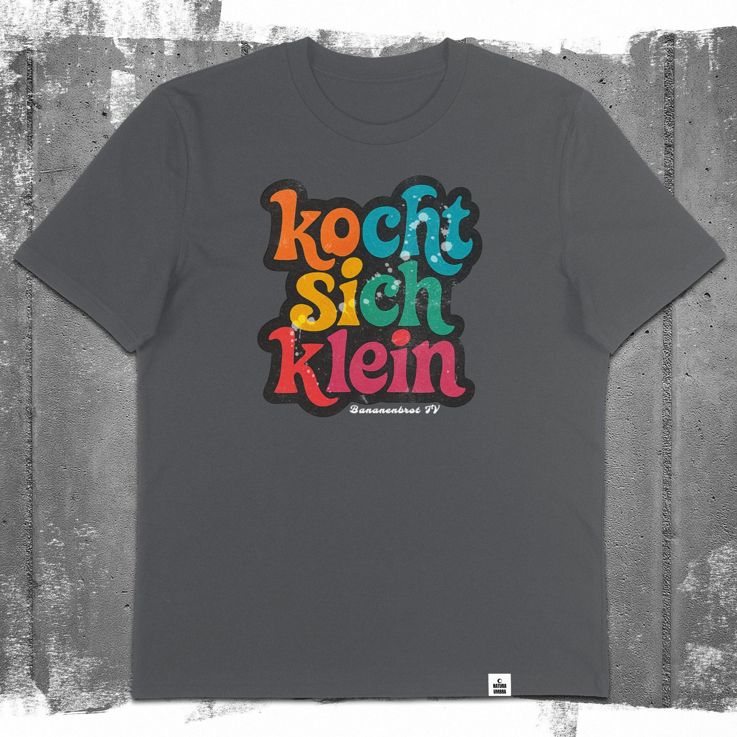 Nachhaltiges Unisex T-Shirt von Natura Umbra in Anthrazit mit Frontprint „Kocht sich klein“ – Flatlay des Stanley/Stella Creator 2.0.